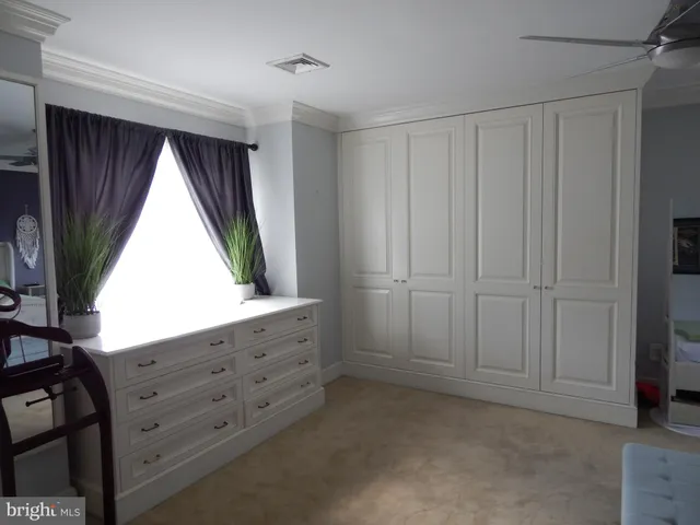 a view of an empty room with a window and closet area