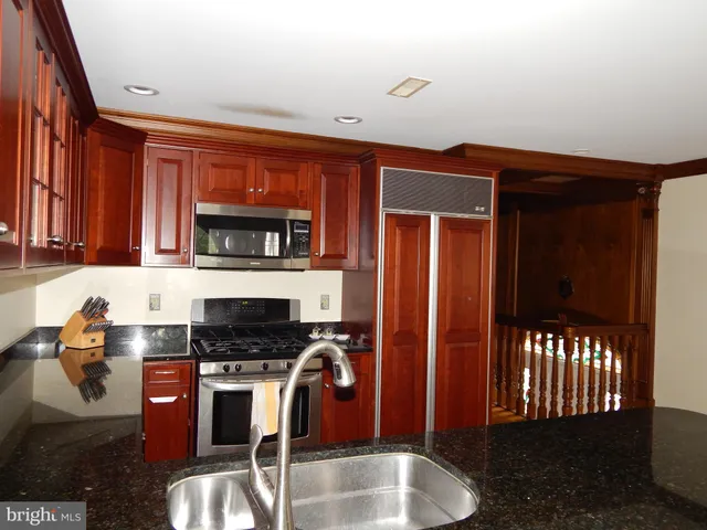 a kitchen with stainless steel appliances granite countertop a stove refrigerator and cabinets