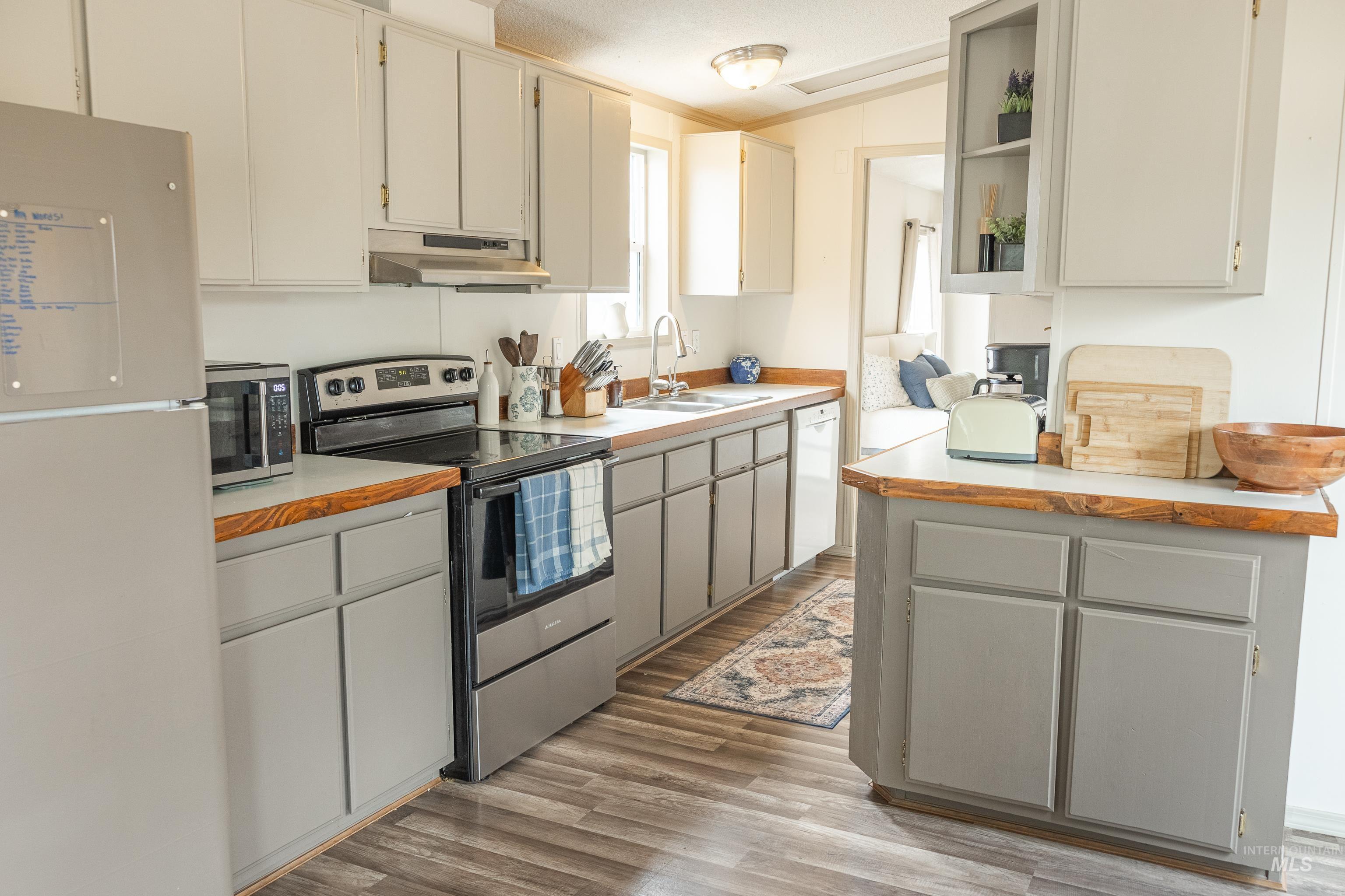4325 Lenville Road, Unit 10 Moscow, ID 83843 - Photo 11 of 21 Kitchen with appliances with stainless steel finishes, light countertops, light wood-style floors, and under cabinet range hood