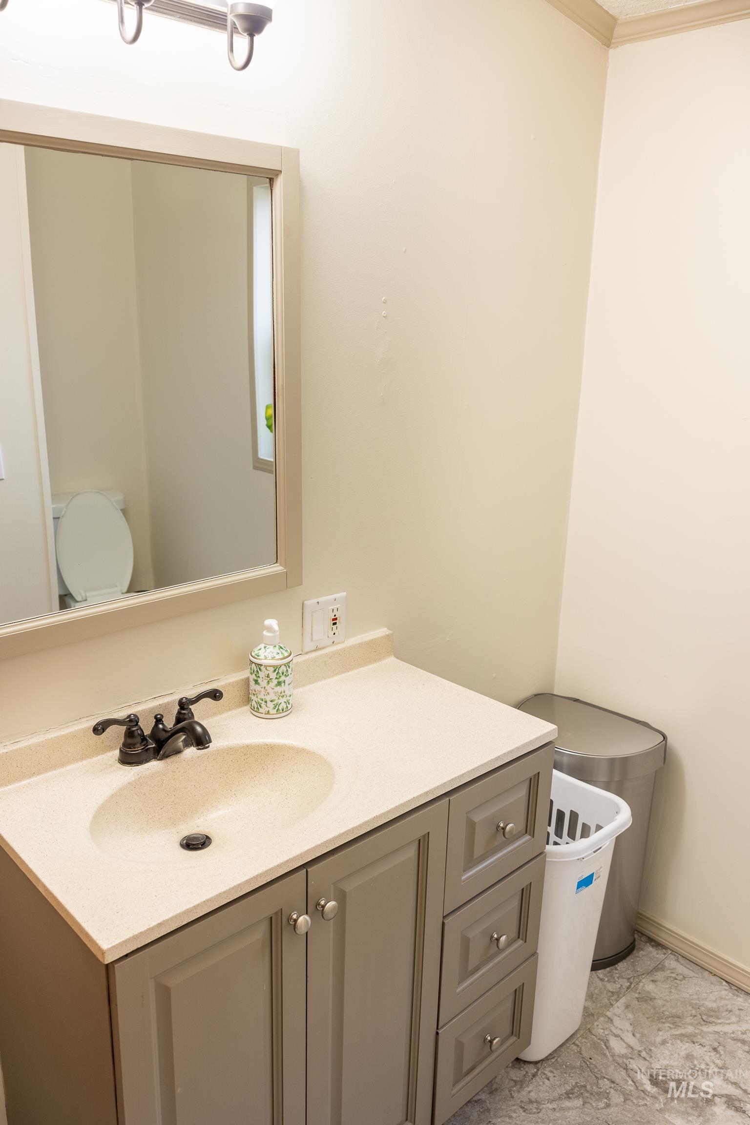 4325 Lenville Road, Unit 10 Moscow, ID 83843 - Photo 15 of 21 Half bath with vanity, light marble finish floors, and ornamental molding