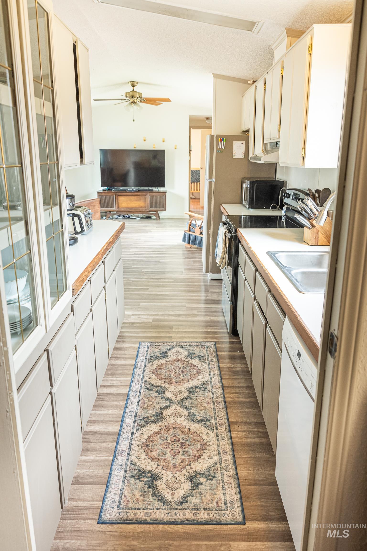 4325 Lenville Road, Unit 10 Moscow, ID 83843 - Photo 21 of 21 Kitchen with white cabinets, light countertops, open floor plan, and appliances with stainless steel finishes