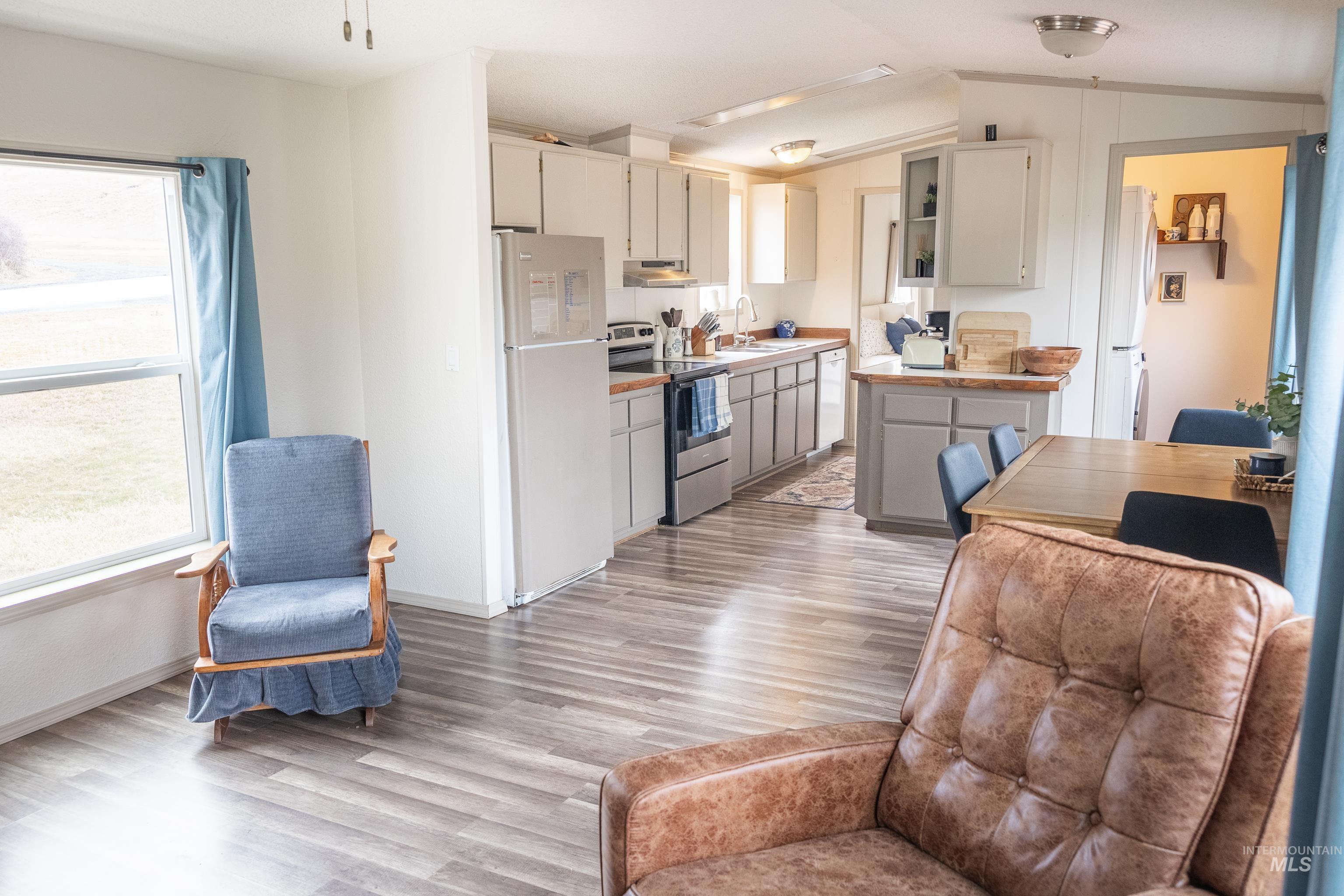 4325 Lenville Road, Unit 10 Moscow, ID 83843 - Photo 7 of 21 Kitchen featuring stainless steel electric range, light countertops, freestanding refrigerator, lofted ceiling, and light wood finished floors