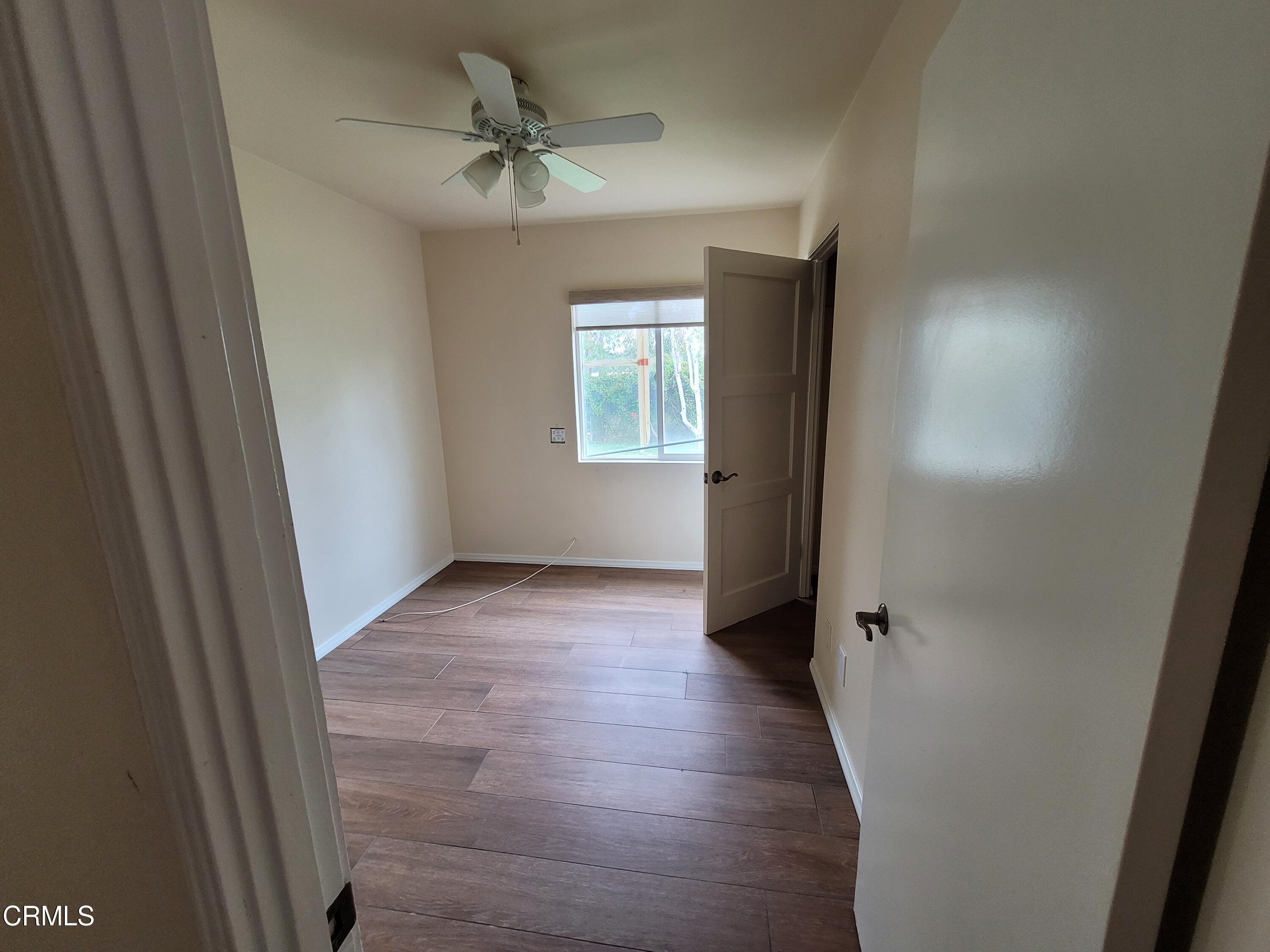 8614 Stockton Road Moorpark, CA 93021 - Photo 11 of 13 an empty room with wooden floor and a ceiling fan