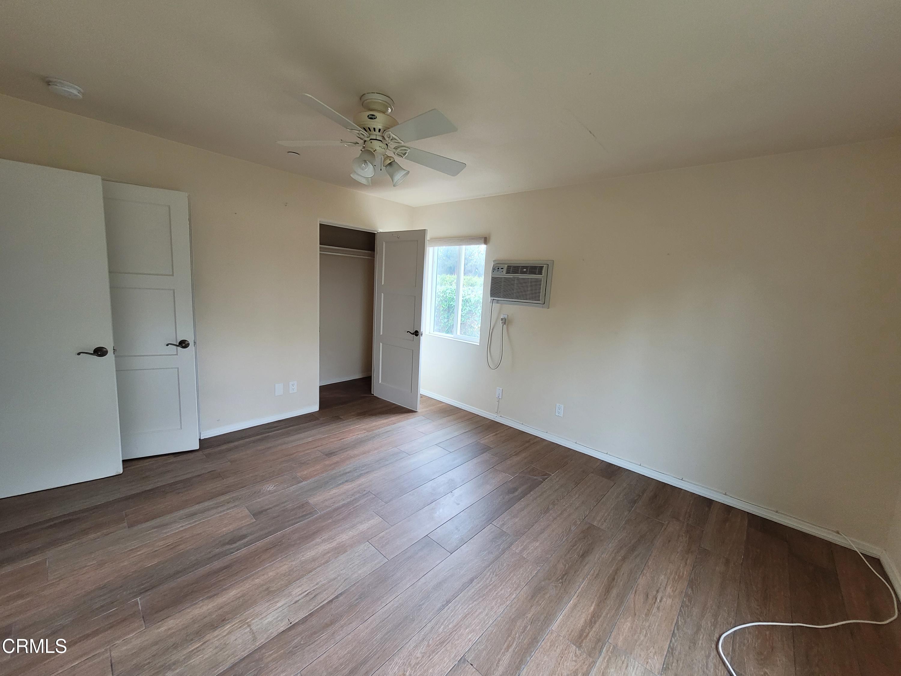 8614 Stockton Road Moorpark, CA 93021 - Photo 12 of 13 a view of an empty room with wooden floor and a window