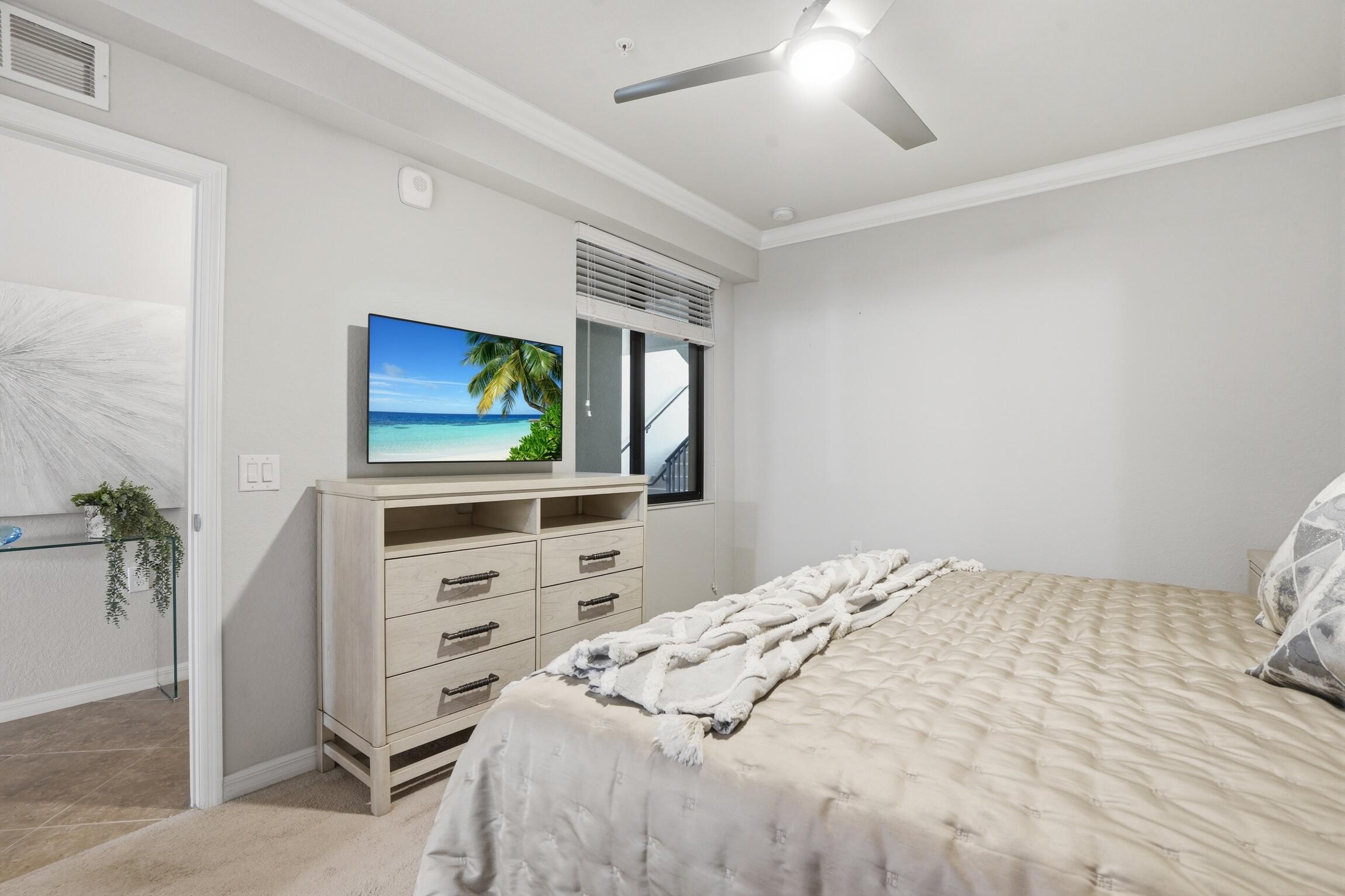 9560 Trevi Court, Unit 4812 Naples, FL 34113 - Photo 14 of 45 a bedroom with a bed and a flat screen tv