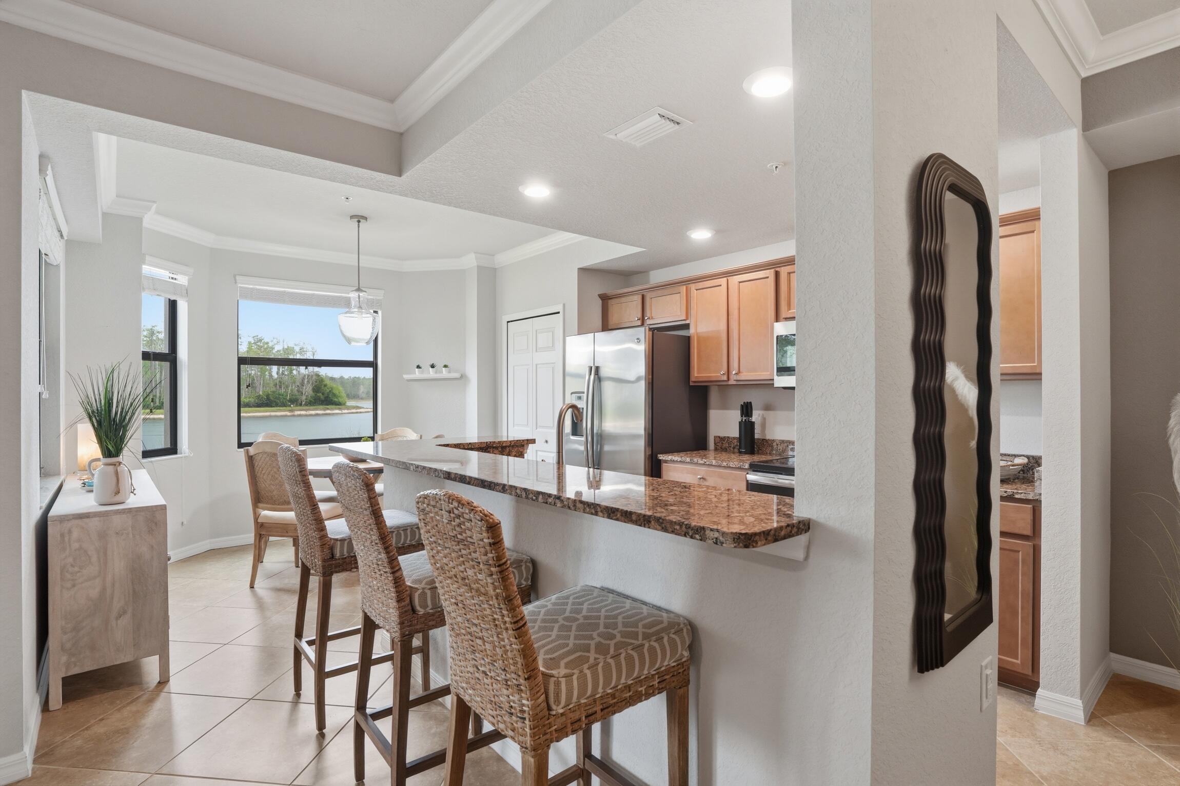 9560 Trevi Court, Unit 4812 Naples, FL 34113 - Photo 10 of 45 a dining area with stainless steel appliances granite countertop furniture and a view of kitchen