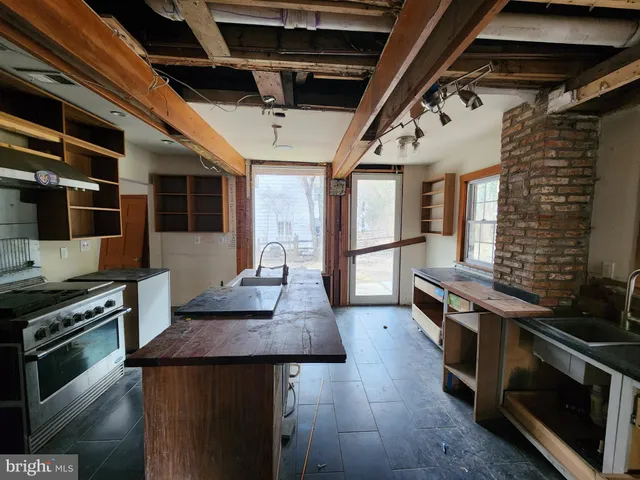 a kitchen with stainless steel appliances wooden floor sink stove and microwave