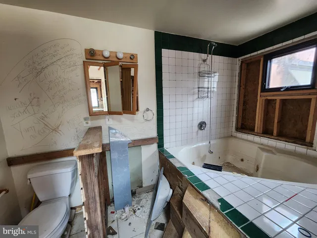 a bathroom with a tub sink and mirror