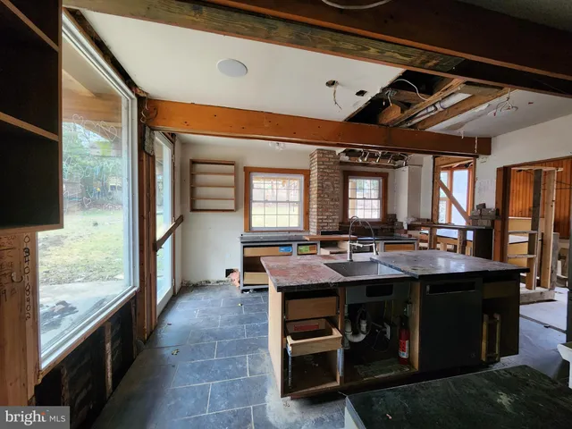 a dining hall with stainless steel appliances granite countertop a stove and a sink