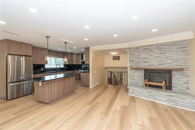 a kitchen with stainless steel appliances kitchen island granite countertop a refrigerator and a stove top oven