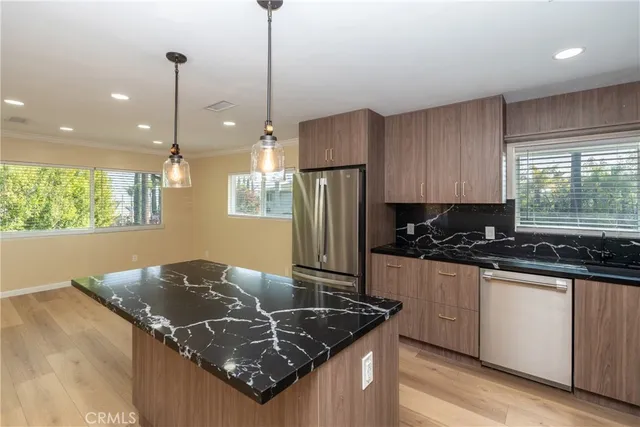 a kitchen with stainless steel appliances granite countertop a sink a stove and a refrigerator