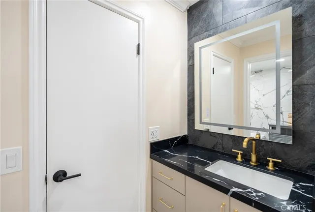 a bathroom with a sink shower and a mirror