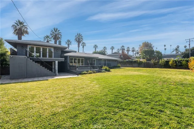 a front view of a house with swimming pool table and chairs