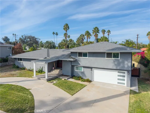 a front view of a house with a garden and mountain view