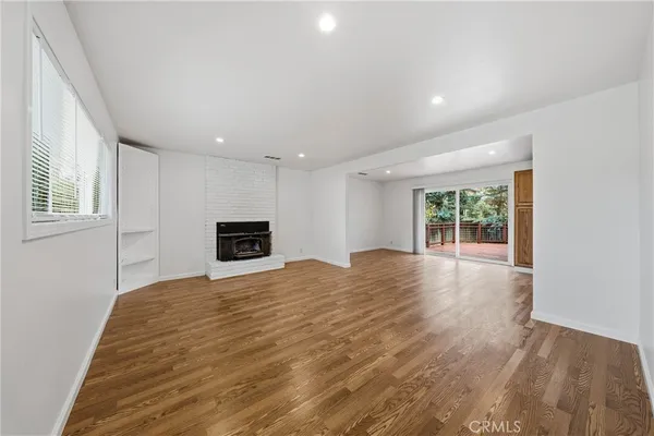 a view of empty room with wooden floor and windows