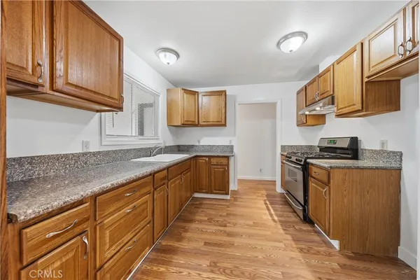 a kitchen with stainless steel appliances granite countertop a stove a sink and a microwave