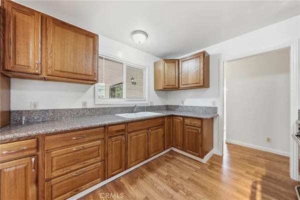 a kitchen with granite countertop cabinets sink and window