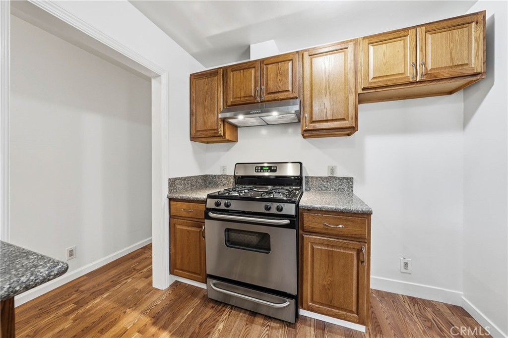 6150 Ridgeview Drive Clearlake, CA 95422 - Photo 17 of 38 a kitchen with granite countertop wooden cabinets stainless steel appliances and a wooden floor