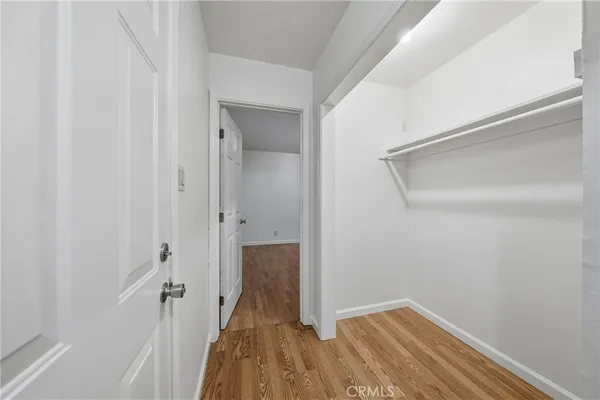 a view of a room with wooden floor and a hallway