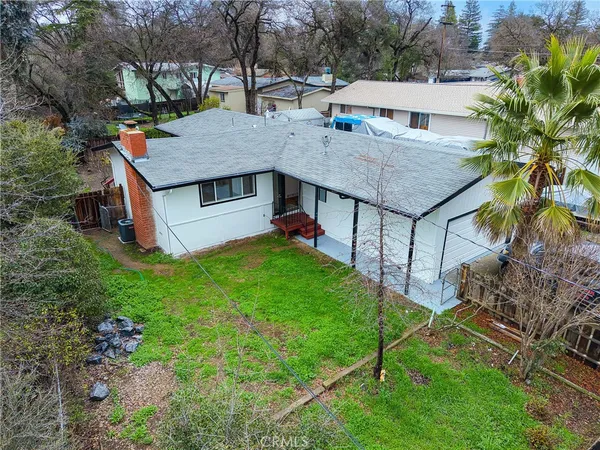 a aerial view of a house with table and chairs under an umbrella