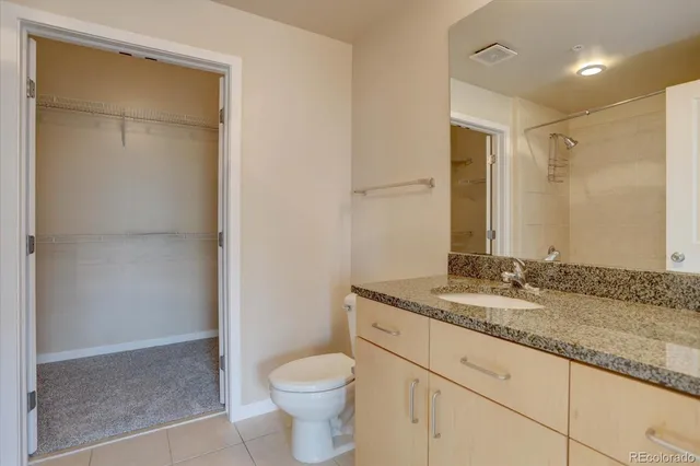a bathroom with a granite countertop sink toilet and shower