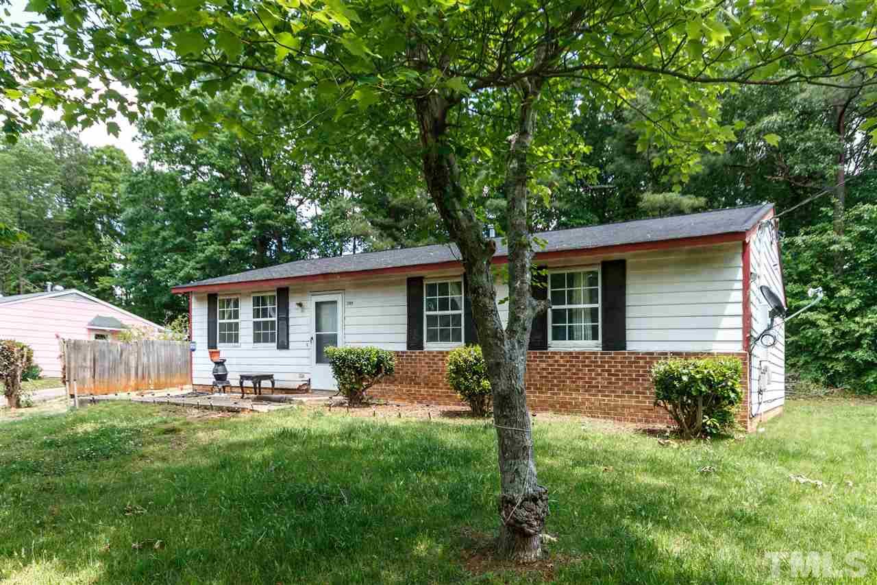 2009 Atkins Drive Raleigh, NC 27610 - Photo 2 of 18 a backyard of a house with table and chairs plants and large tree