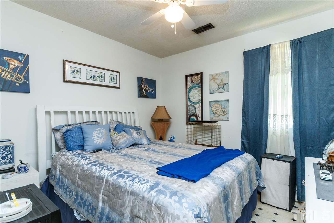 2009 Atkins Drive Raleigh, NC 27610 - Photo 12 of 18 a bedroom with a large bed and a chandelier