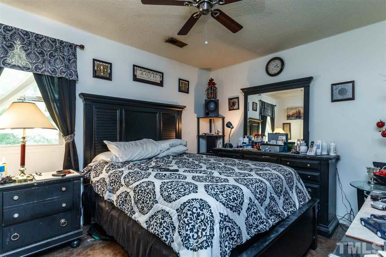 2009 Atkins Drive Raleigh, NC 27610 - Photo 10 of 18 a bedroom with a bed and a chandelier