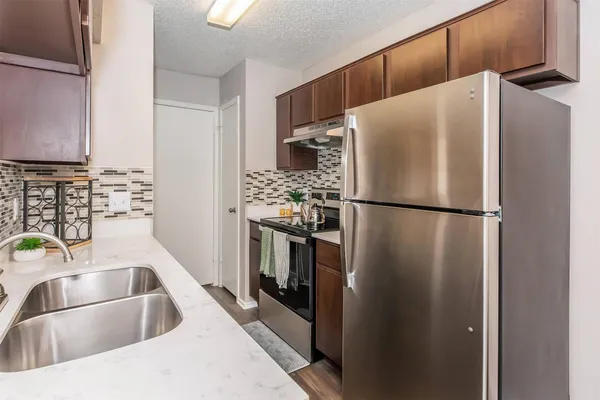 a kitchen with stainless steel appliances a refrigerator sink and cabinets