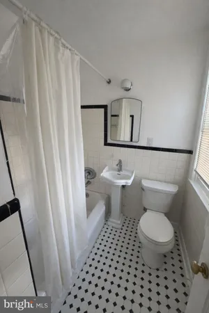 a bathroom with a toilet and a shower curtain
