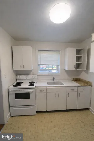 a kitchen with granite countertop a sink and a stove