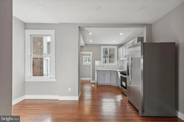a view of a kitchen with a refrigerator cabinets and wooden floor