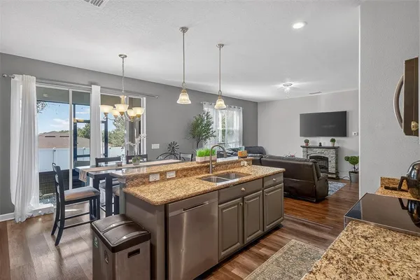 a kitchen with granite countertop a sink appliances and cabinets