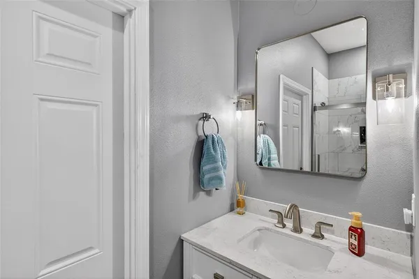 a view of a hallway with bathroom and wooden floor