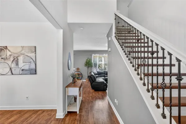 a view of a hallway with wooden floor and staircase