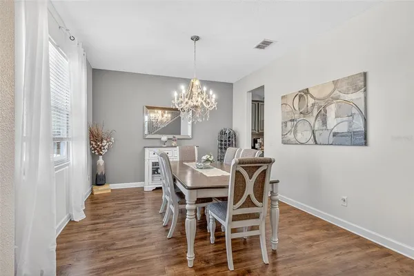 a kitchen with a stove a sink a counter top space and living room view