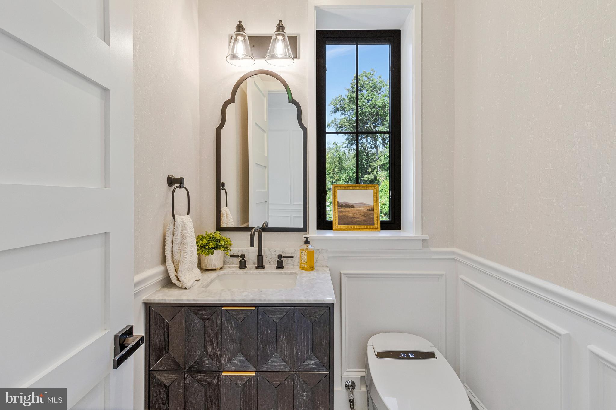 7709 Sebago Road Bethesda, MD 20817 - Photo 28 of 68 a bathroom with a granite countertop sink a toilet and a mirror