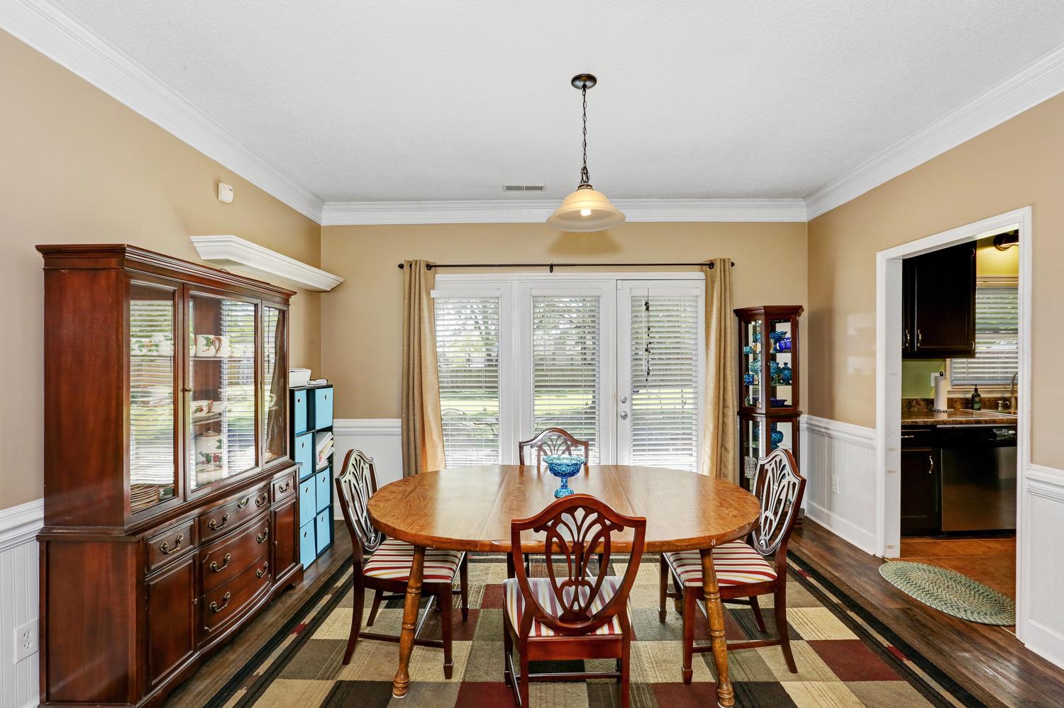 126 Raspberry Way Madison, AL 35757 - Photo 12 of 25 Dining Room - With crown molding, laminate flooring, chair rail and wainscoting. The door leads to the back patio.