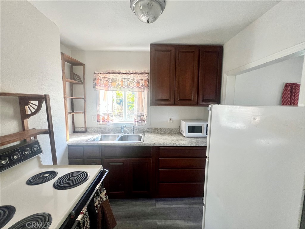 13992 Lakeshore Drive Clearlake, CA 95422 - Photo 19 of 35 a kitchen with a sink a stove a refrigerator and a window