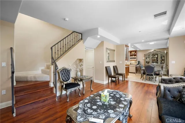 a living room with furniture a wooden floor and a chandelier
