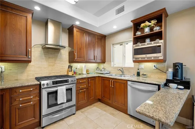 a kitchen with stainless steel appliances granite countertop a stove and cabinets
