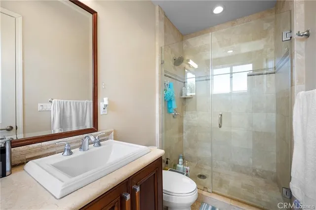 a bathroom with a sink mirror toilet and shower
