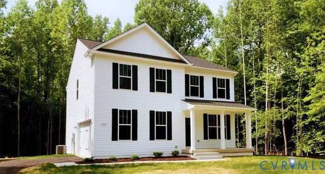 a view of a white house with large windows and a small yard