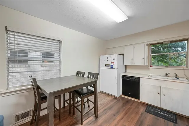 a kitchen with a table chairs a sink dishwasher window and cabinets