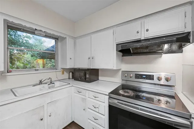 a kitchen with appliances a sink and cabinets