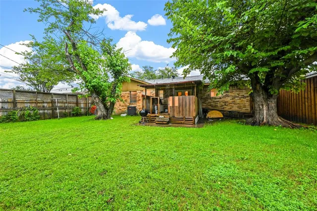 a view of a house with backyard and a tree