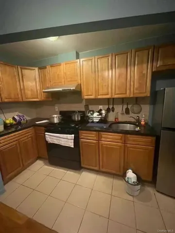 a kitchen with a sink a stove cabinets and a window