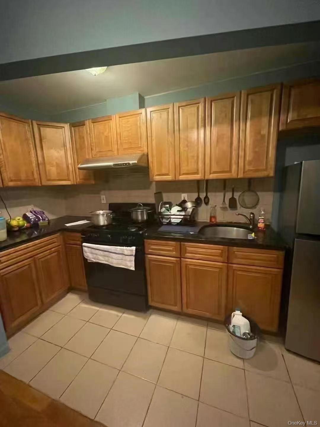 37-41 98th Street Queens, NY 11368 - Photo 3 of 9 a kitchen with a sink a stove cabinets and a window