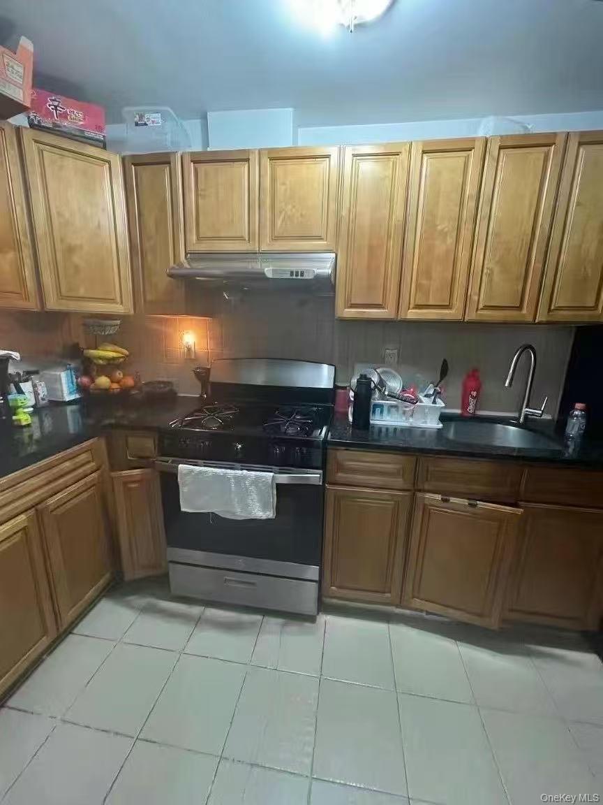 37-41 98th Street Queens, NY 11368 - Photo 5 of 9 a kitchen with granite countertop a sink and cabinets