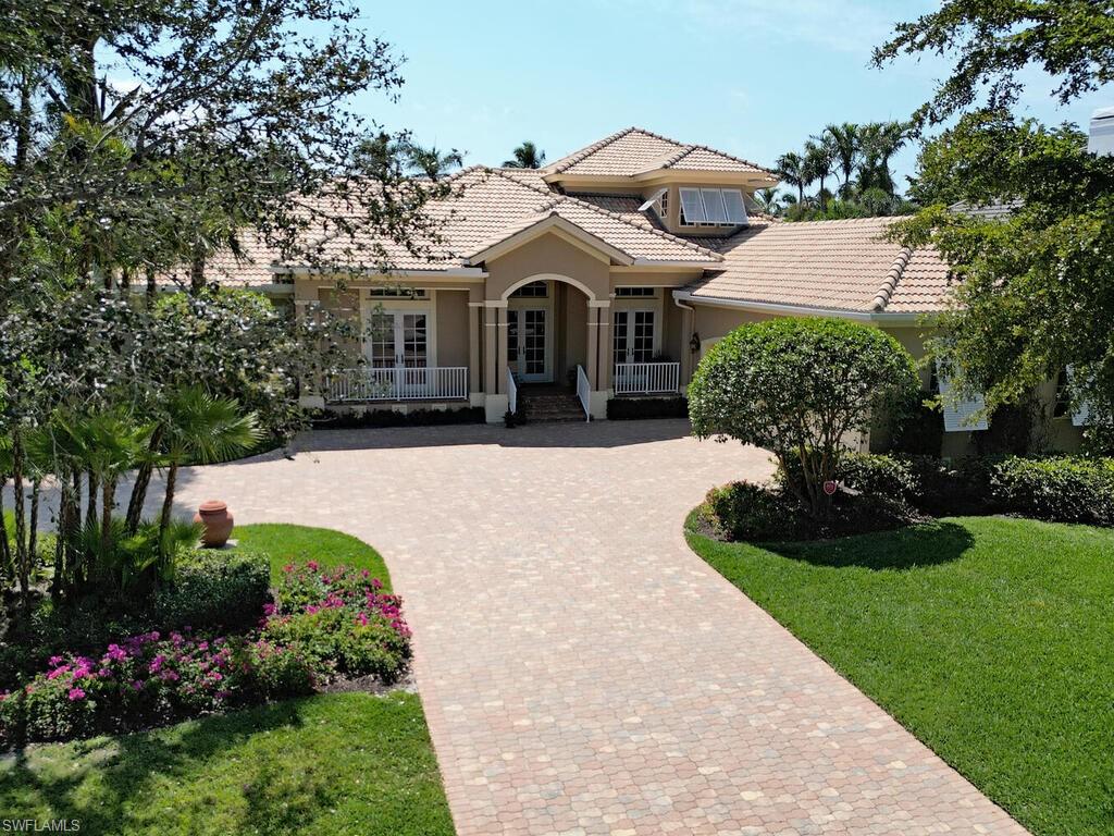 650 Bow Line Drive Naples, FL 34103 - Photo 2 of 18 a front view of a house with a garden and trees